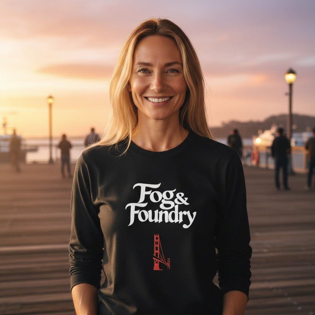 A smiling woman wearing a black Fog & Foundry long-sleeve cotton shirt with a Golden Gate Bridge graphic on a pier.