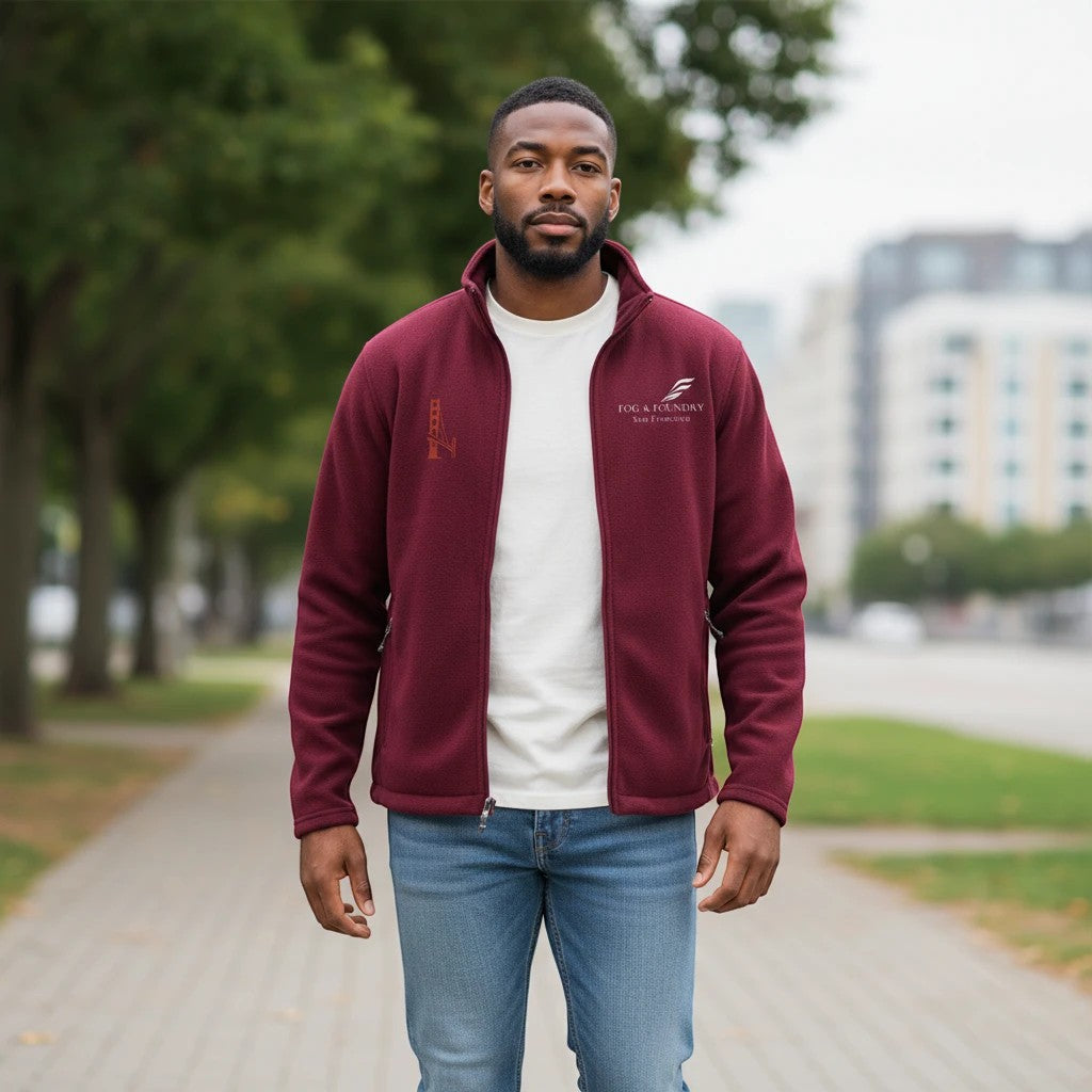 Man wearing a burgundy Fog & Foundry full-zip fleece jacket with a stand-up collar and embroidered logo.