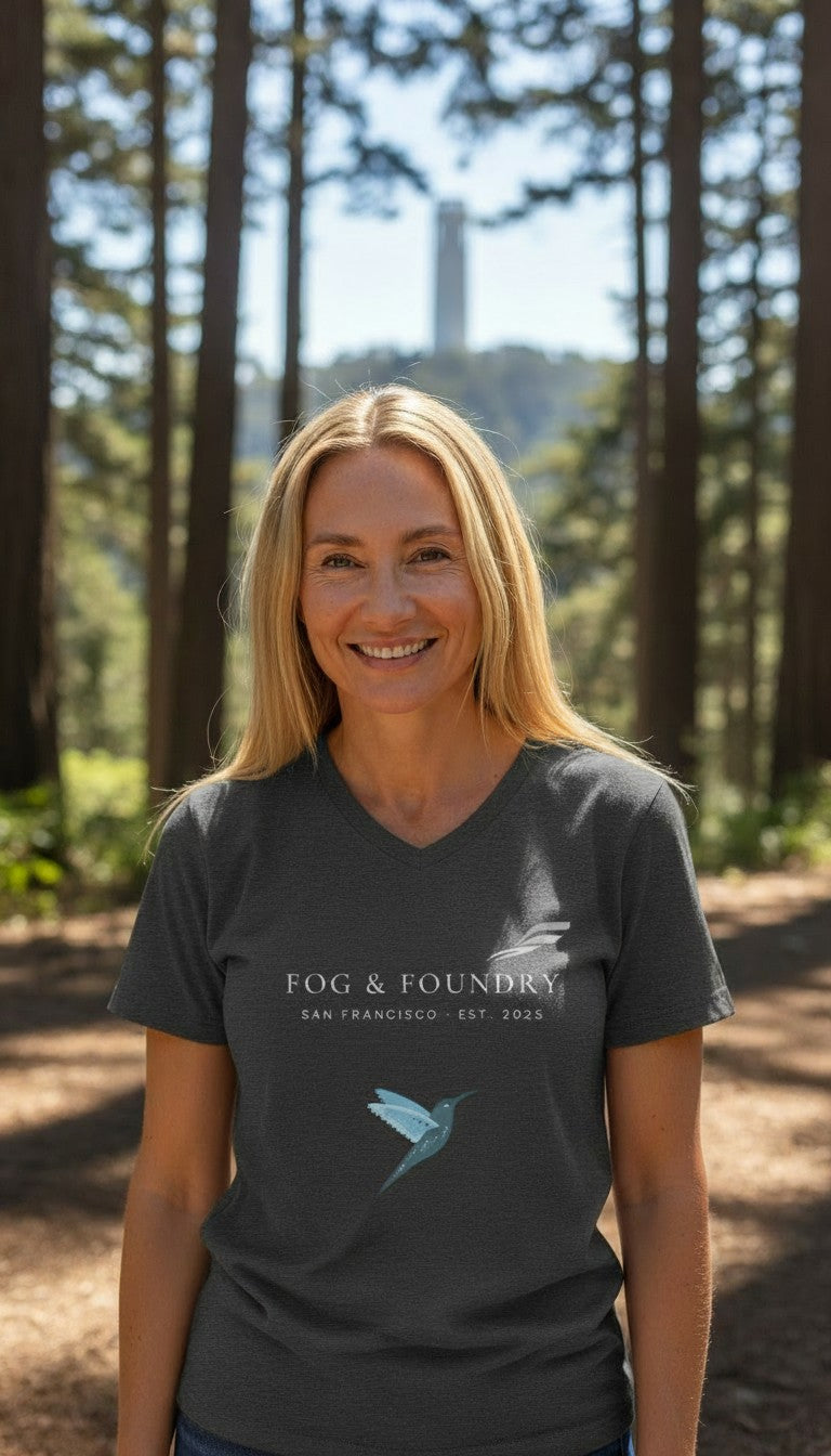 Woman wearing a Fog & Foundry gray cotton v-neck t-shirt with a hummingbird logo in a forest setting