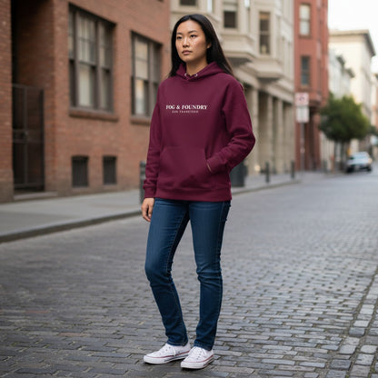 A woman wearing a maroon Fog & Foundry organic cotton raglan hoodie with jeans on a San Francisco city street.
