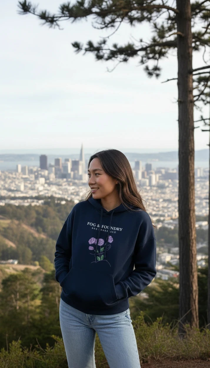 Woman wearing a navy Fog & Foundry organic cotton mid-length hoodie with a floral graphic overlooking San Francisco.