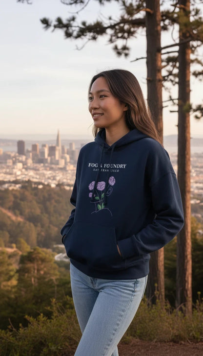 Woman wearing a navy Fog & Foundry organic cotton mid-length hoodie with a floral graphic, overlooking San Francisco.
