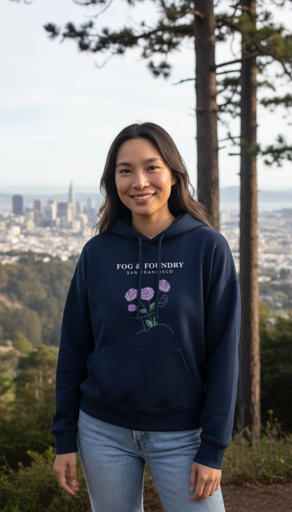 Woman wearing a navy Fog & Foundry organic cotton mid-length hoodie with a floral graphic, outdoors in San Francisco.