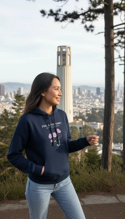 Woman wearing a navy Fog & Foundry organic cotton mid-length hoodie with a floral graphic overlooking San Francisco.