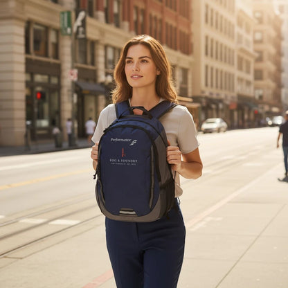 Woman wearing a Fog & Foundry navy Ridge backpack while walking down a sunny San Francisco city street.