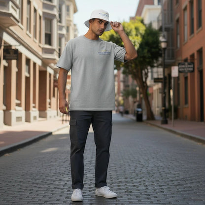 Fog & Foundry cotton twill bucket hat in white worn by a man in a gray t-shirt on a city street.