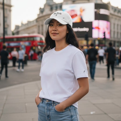 A woman wearing a white Fog & Foundry Japan Cap with a curved visor in a busy city setting.