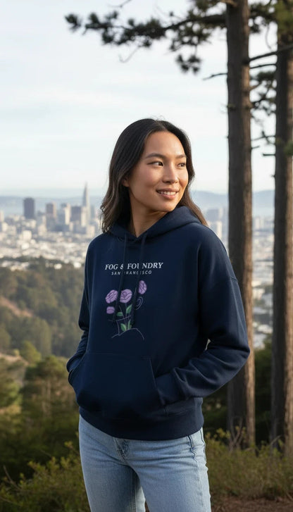 Woman wearing a navy Fog & Foundry organic cotton mid-length hoodie with a floral graphic, overlooking San Francisco.