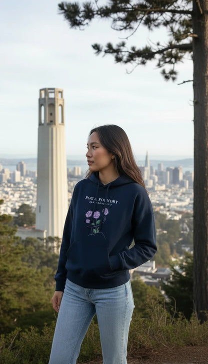 Woman wearing a navy Fog & Foundry organic cotton mid-length hoodie with a floral graphic overlooking San Francisco.